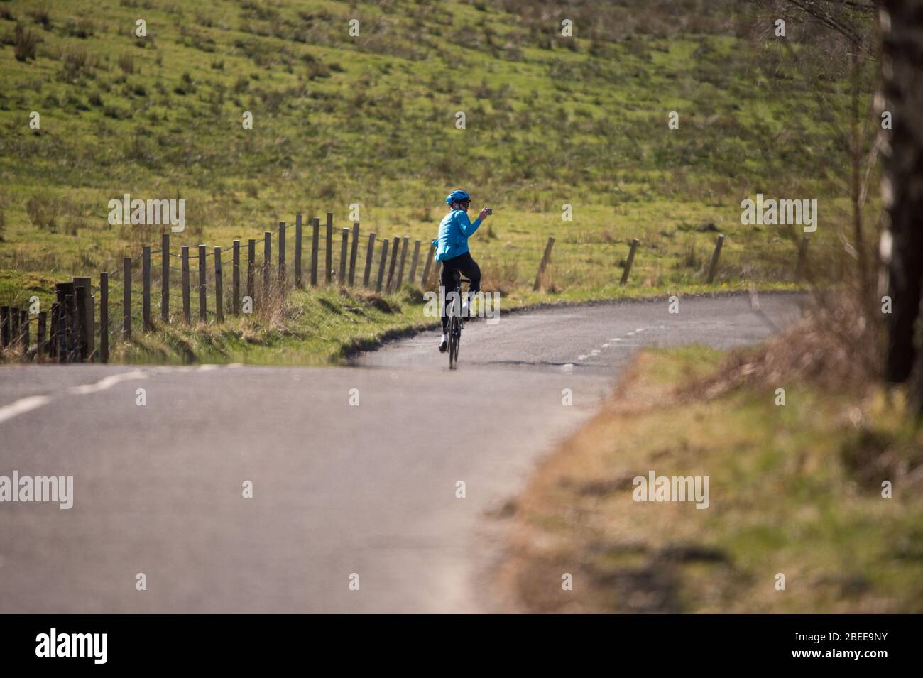 Cumbernauld, Royaume-Uni. 13 avril 2019. Photo: Un cycliste est vu prendre un selfie tout en conduisant son vélo pendant le Lockdown sur un brillant et chaud soleil printemps Bank vacances lundi de Pâques. En raison du verrouillage du Coronavirus (COVID-19) imposé par les gouvernements britannique et écossais, la police a fait respecter le verrouillage et les gens ont pris l'avertissement au sérieux, tous les points d'accès touristiques et de beauté étant cordonés avec des barrages routiers. Crédit : Colin Fisher/Alay Live News Banque D'Images