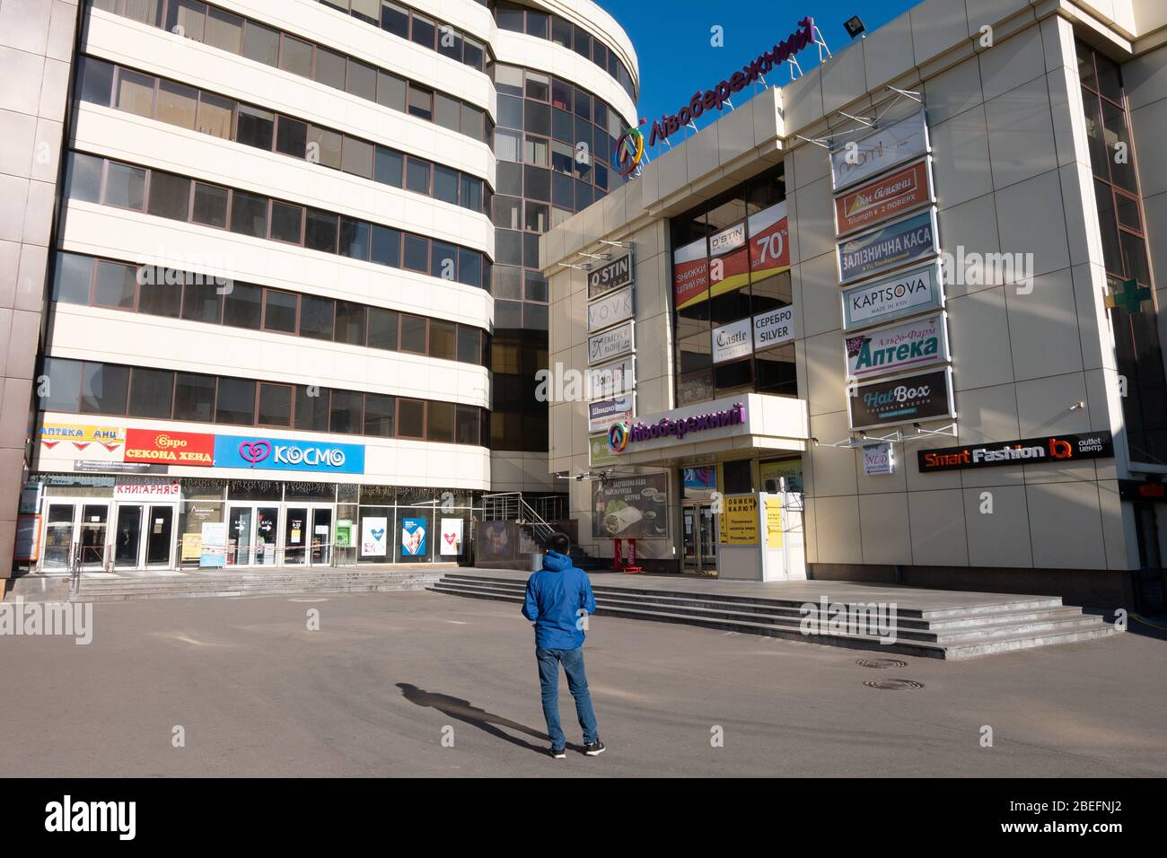 KIEV, UKRAINE - 5 AVRIL 2020: Centre commercial de livoberezhnyi fermé avec un seul homme devant lui. Endroit vide inhabituel près du métro Livoberezhna Banque D'Images