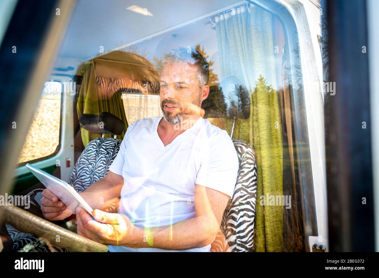 Portrait de l'homme avec lunettes de soleil pendant les vacances dans sa camionnette Banque D'Images