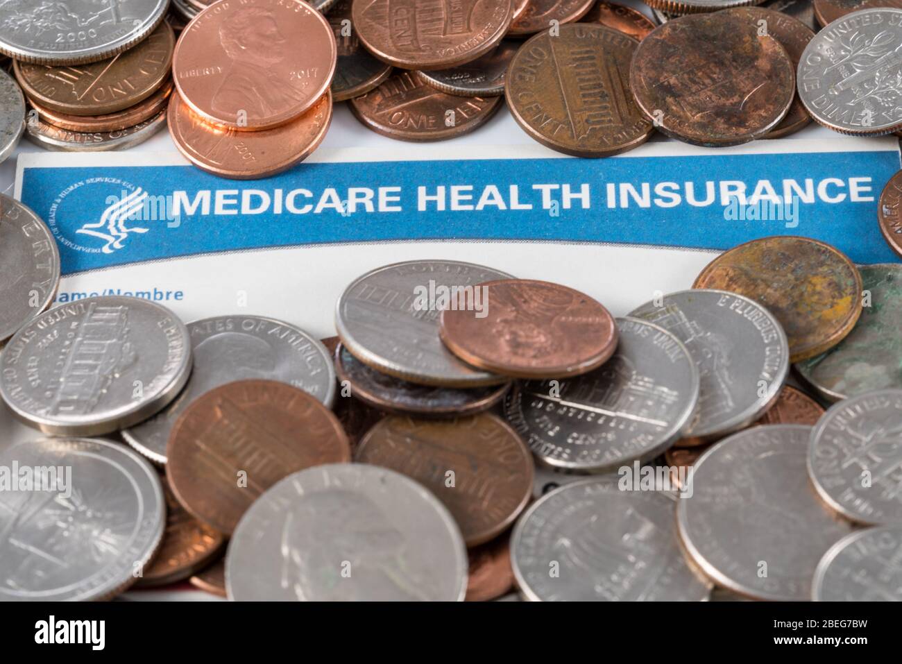 USA carte d'assurance maladie Medicare avec des piles de changements et d'argent pour montrer la crise de financement Banque D'Images