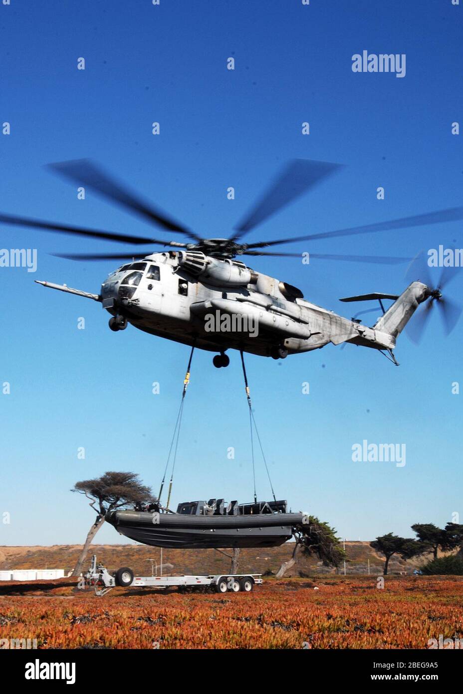 Un hélicoptère soulève un bateau rigide gonflable de Hull Banque D'Images