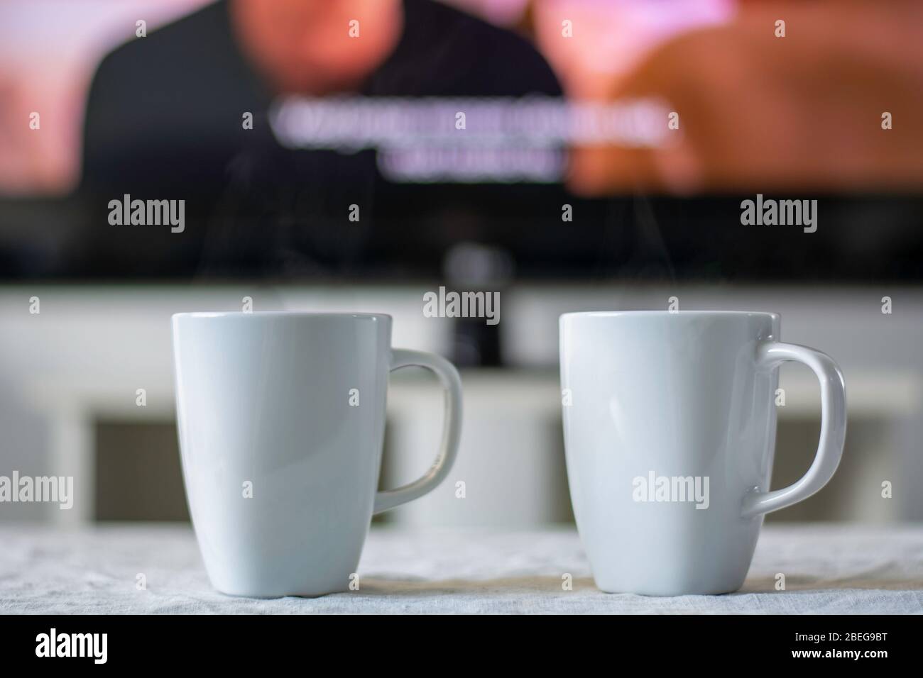 Tasses à café avec un écran de télévision avec un film et sous-titres en arrière-plan. Banque D'Images
