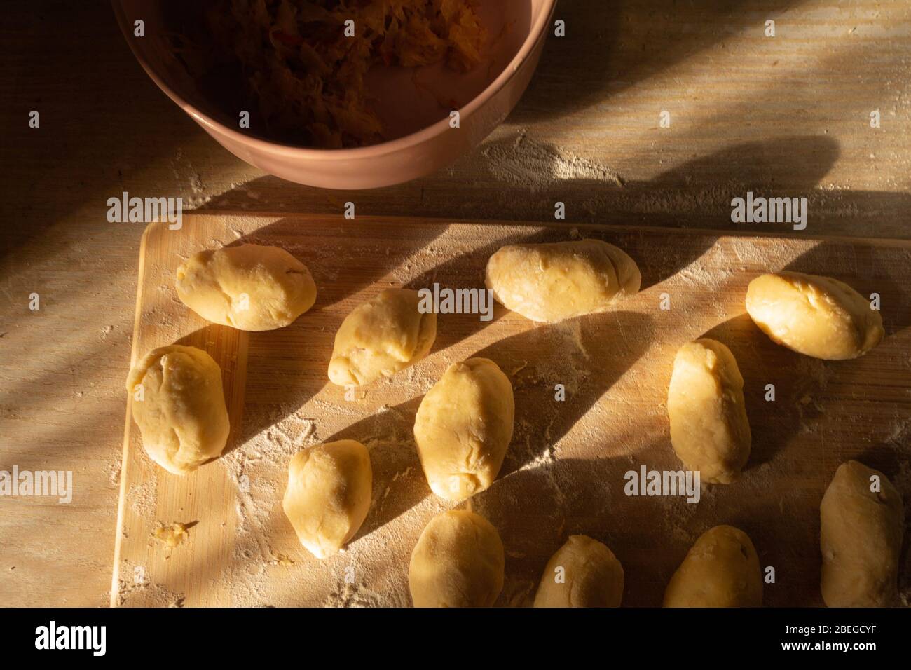 Tartes de pommes de terre au chou avant de cuire sur un tableau de découpe. Banque D'Images