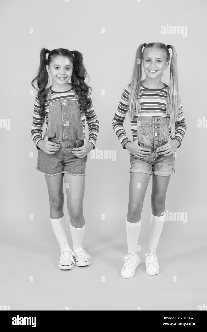 Tendance et fantaisie. Les petites filles portant des vêtements arc-en-ciel. Les tenues correspondantes. Boutique de mode. Doit avoir l'accessoire. Les couleurs sont éclatantes. La mode moderne. Kids Fashion. Pour les cheveux longs. Enfants mignon même tenues. Banque D'Images