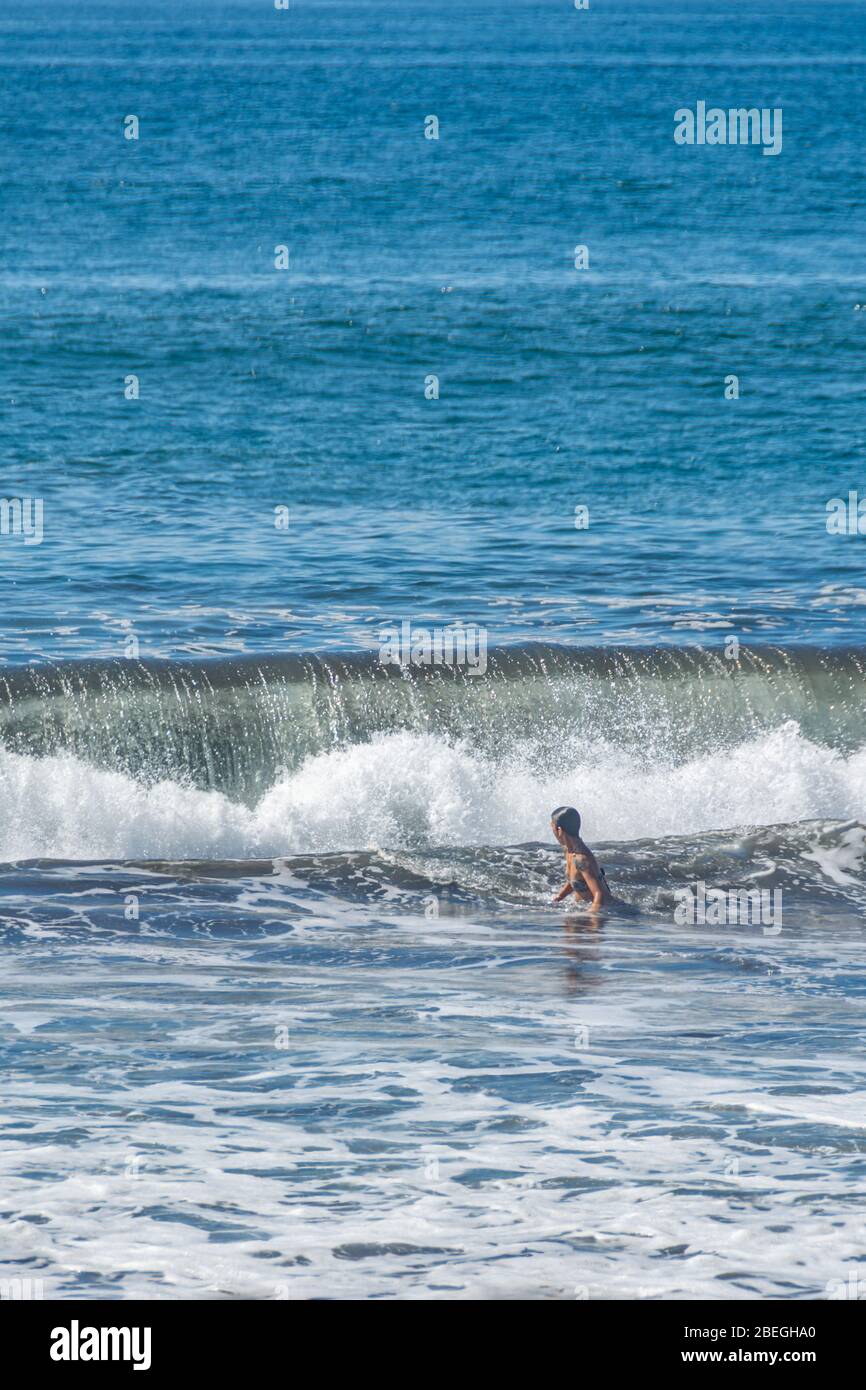 Femme en maillot de bain appréciant l'océan à Monterrico Beach, Guatemala Banque D'Images