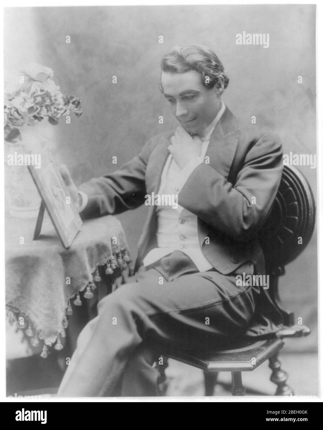 Henry B. Walthall, longueur de trois quarts, assis sur une chaise, face vers la gauche, la main sous le menton, à la recherche de photo Banque D'Images