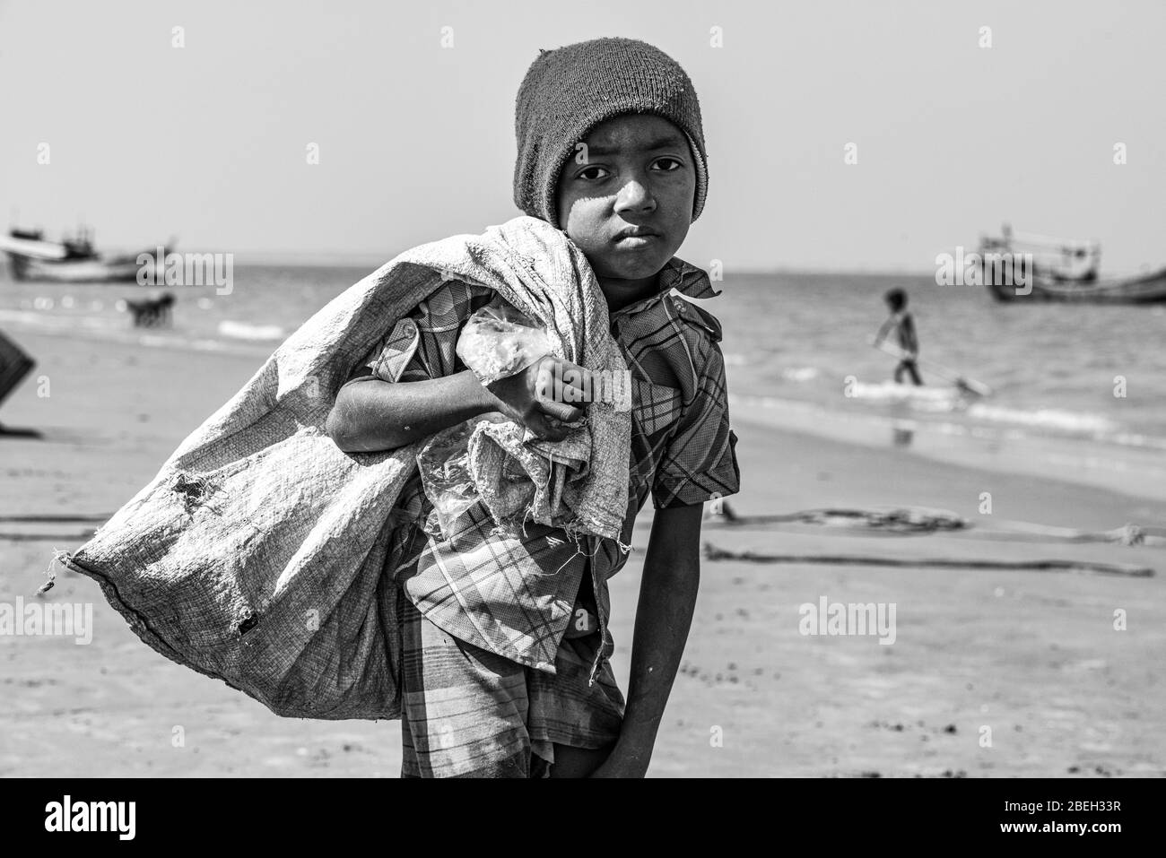 Sac de transport Sad Boy près de la mer dans un village de pêche au nord de Cox's Bazar Banque D'Images