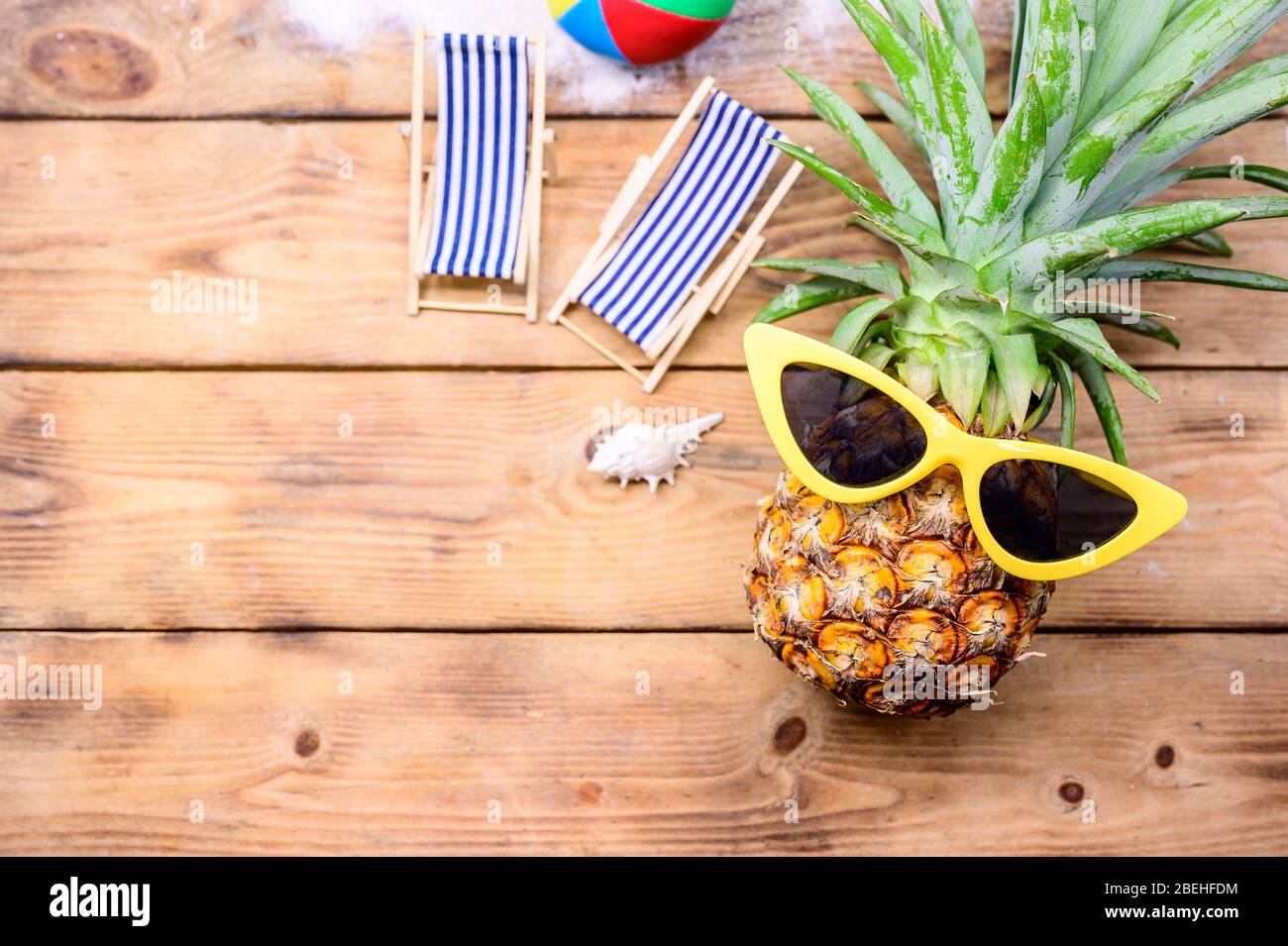 Ananas avec lunettes de soleil sur fond de bois. Concept de vacances d'été  minimaliste créatif avec jouet miniature Photo Stock - Alamy