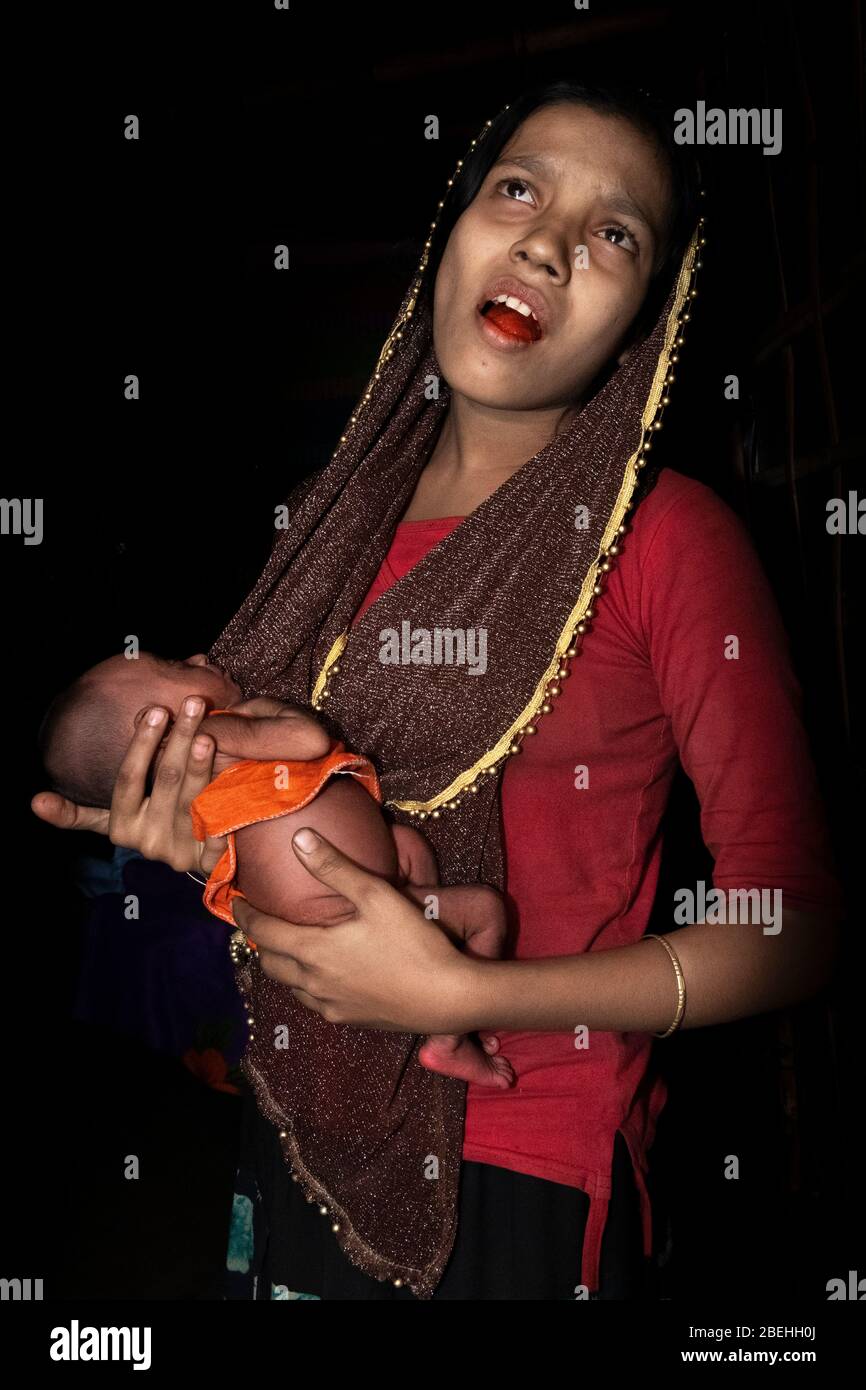 Rohingya mère de bas âge transportant bébé dans un camp de réfugiés, au sud de Cox's Bazar près de la frontière avec le Myanmar. Banque D'Images