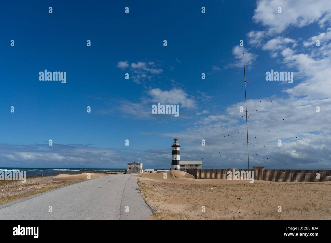 Route asphaltée et phare blanc et noir du Cap Recife Banque D'Images