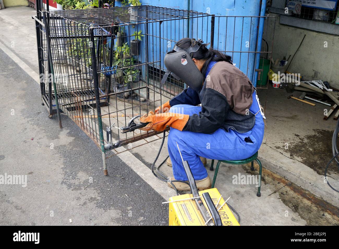 Antipolo City, Philippines - 13 avril 2020: Un travailleur qualifié a soudé des barres de fer ensemble pour former une cage de chien. Banque D'Images