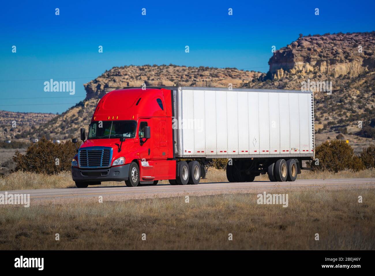 Tracteur de grande plate-forme à dix-huit roues avec remorque sur route. Industrie du camionnage Banque D'Images