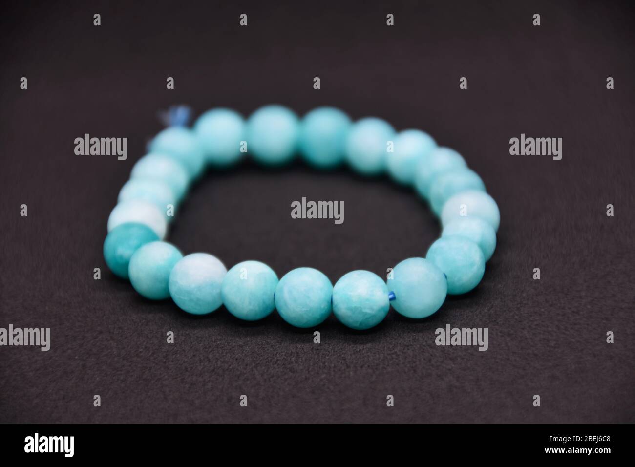 Bracelet fait maison de perles de pierre semi-précieuses bleu naturel sur fond noir Banque D'Images