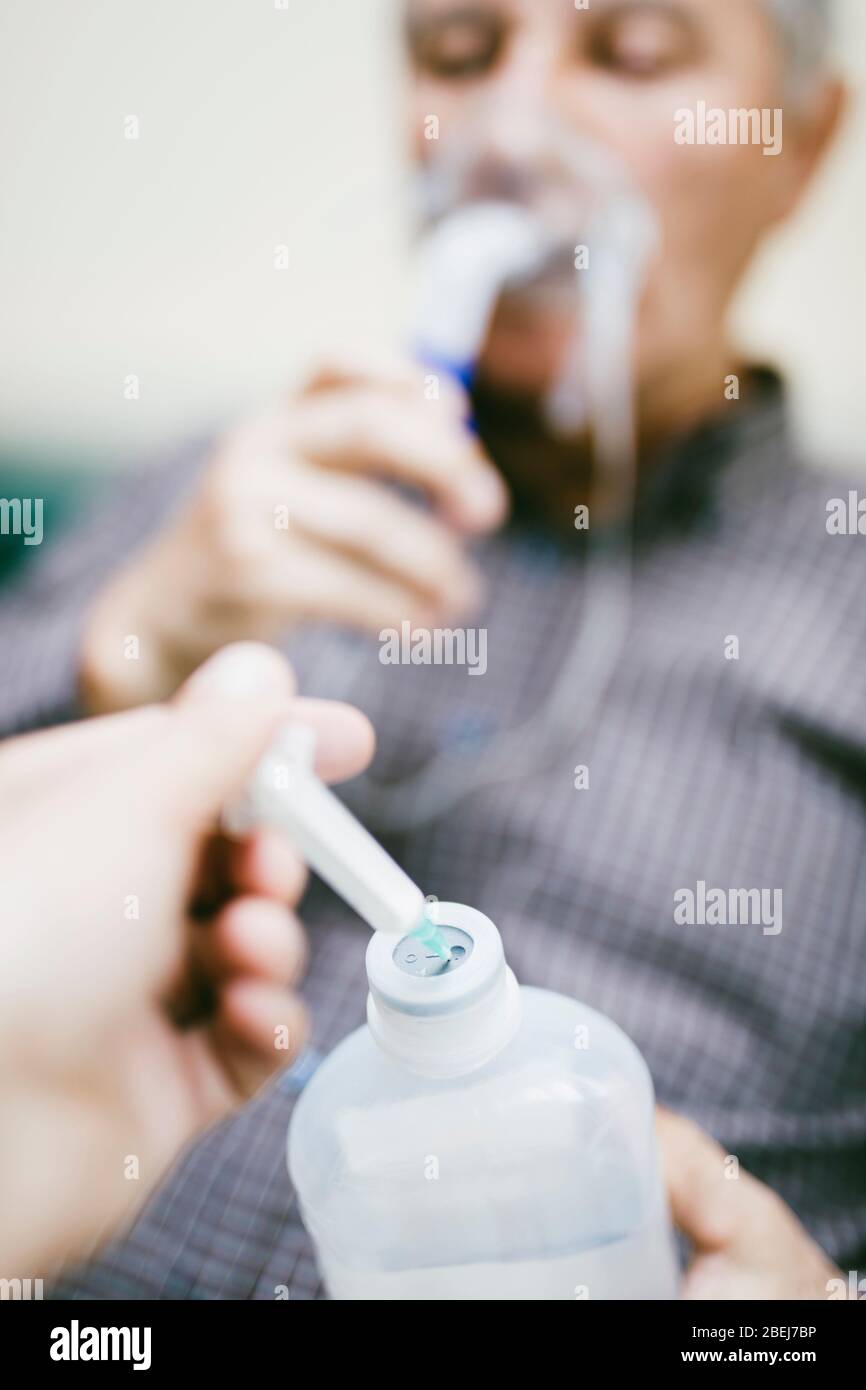 Préparation du nébuliseur à compresseur pour l'homme senior avec masque respiratoire, nébuliseur dans la salle Banque D'Images
