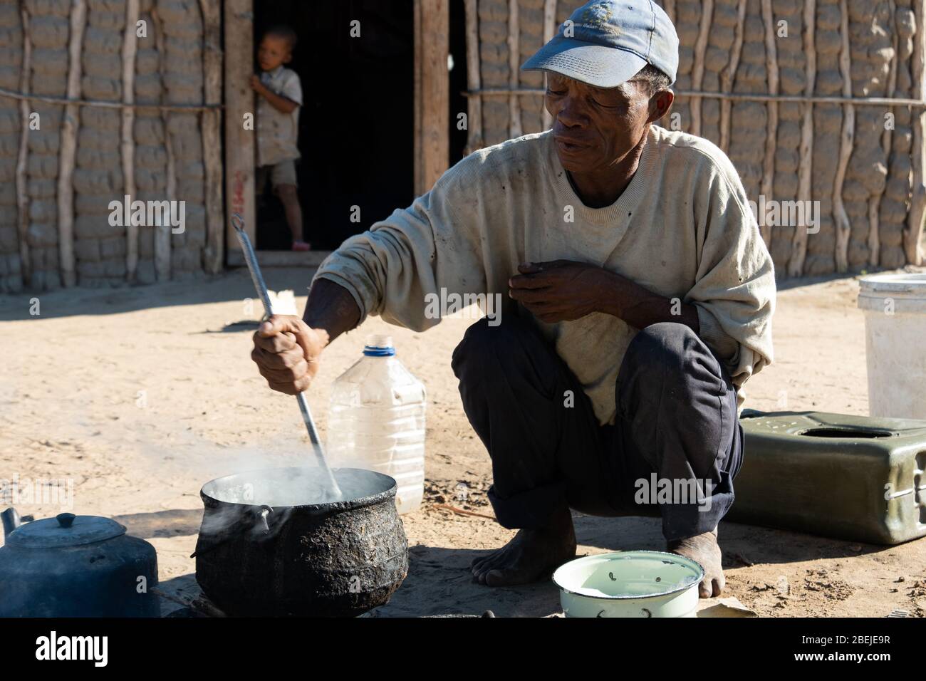 Un Bushman du village de Deng//e cuisiniers pour ses enfants à Nyae Nyae, en Namibie. Banque D'Images