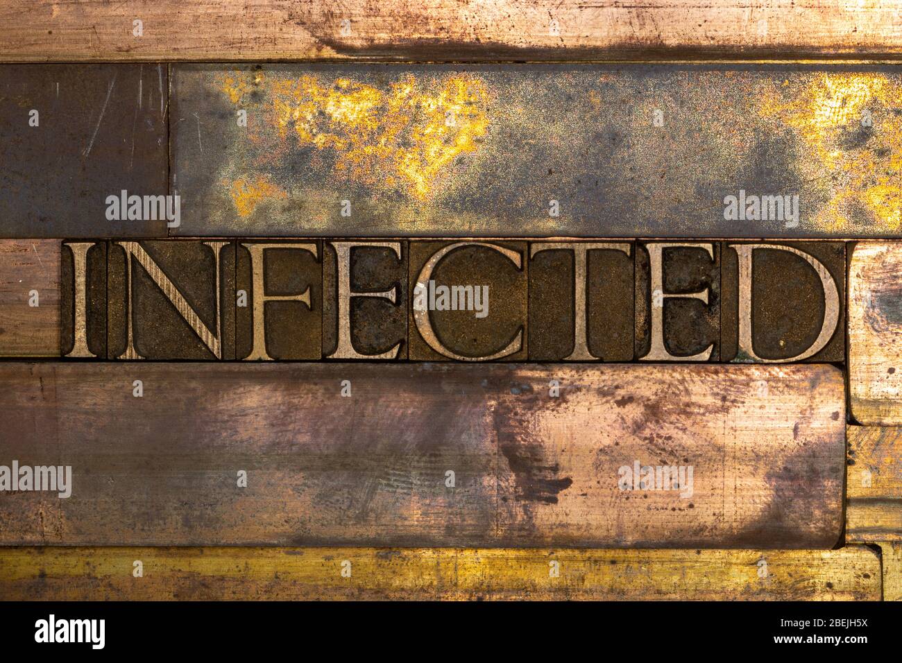 Photo de véritables lettres de composition authentiques formant du texte infecté sur fond de cuivre grunge texturé vintage Banque D'Images