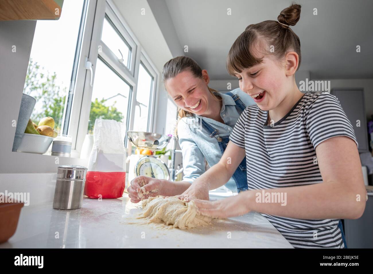 Mère et fille ayant plaisir dans la cuisine à faire de la pâte pour le pain maison cuit ensemble Banque D'Images