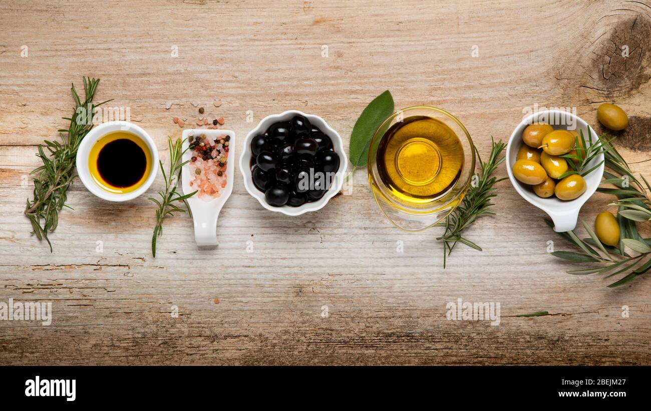 vue sur le dessus, sur la table rustique en bois, l'arrangement de bols avec olives, variété d'épices, branche d'olive et huile d'olive extra vierge. Toujours la vie Banque D'Images