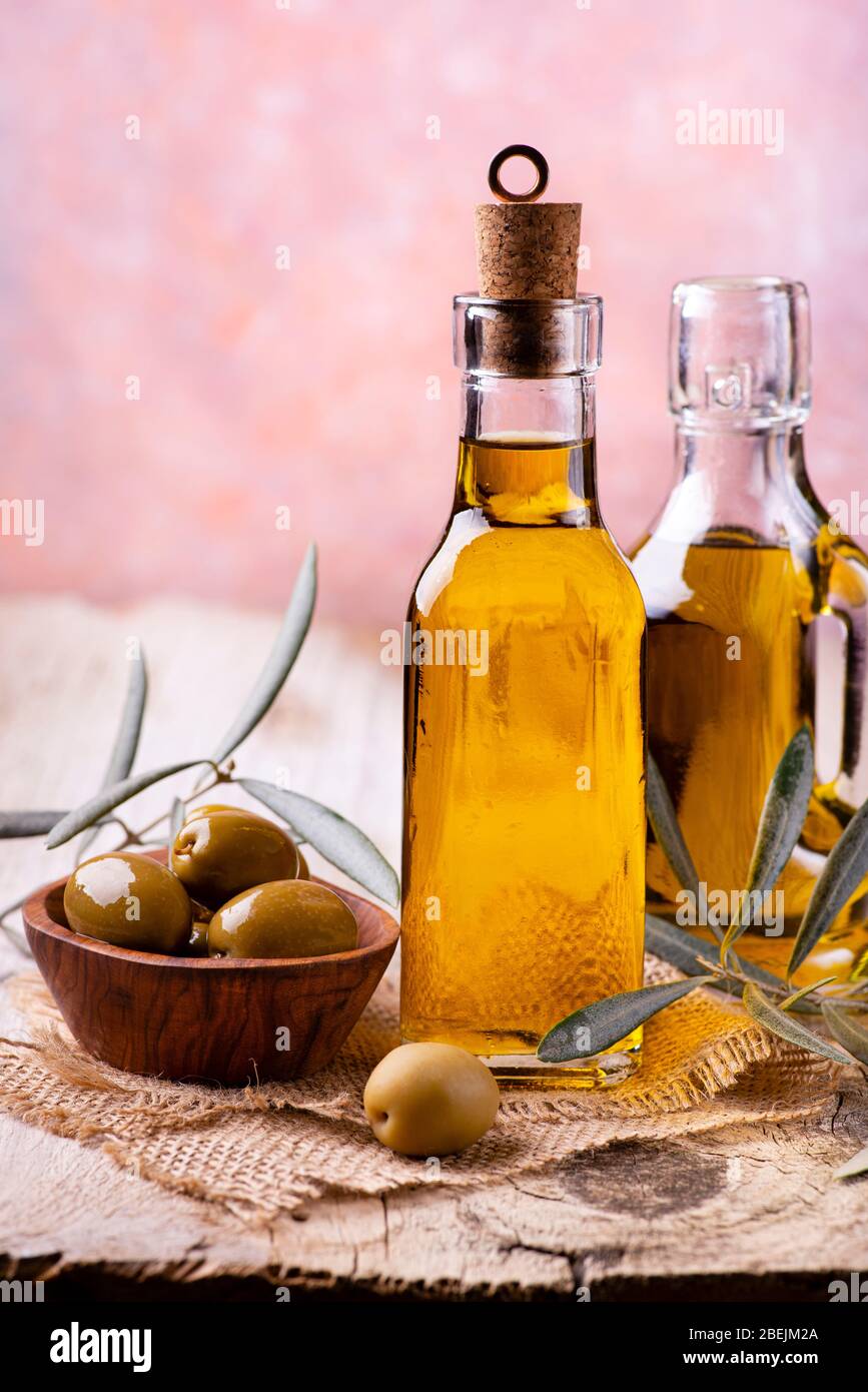 sur la table rustique en bois, bouteille d'huile d'olive extra vierge et olives dans le bol en bois Banque D'Images