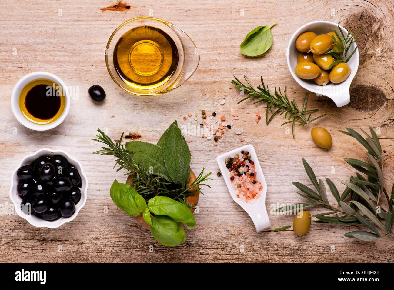 vue sur le dessus, sur la table rustique en bois, l'arrangement de bols avec olives, variété d'épices, branche d'olive et huile d'olive extra vierge. Toujours la vie Banque D'Images