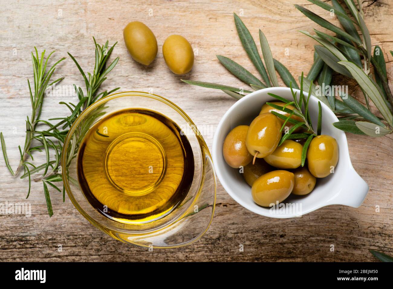 vue de dessus, en premier plan, sur la table rustique en bois, les bols aux olives, au romarin et à l'huile d'olive extra vierge. Toujours la vie Banque D'Images