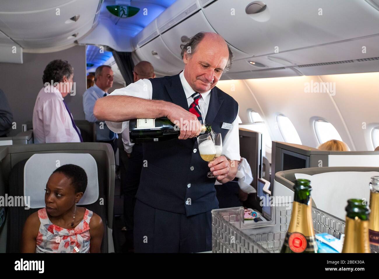 Johannesburg, Afrique du Sud - 06 février 2014 : équipage de cabine masculin qui verse un verre de Champaign dans la classe affaires d'un Airbus A 380 Banque D'Images