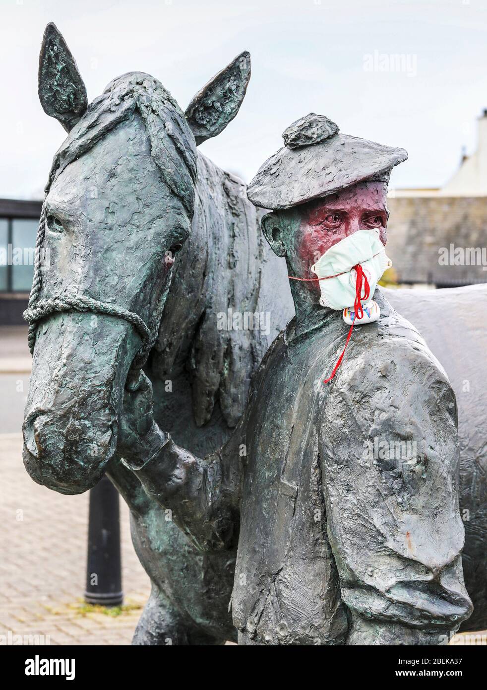 Irvine, Royaume-Uni. 14 avril 2020. La statue emblématique du carter et de son cheval Clydesdale au port d'Irvine représente les connexions nationales et internationales de la ville et sa résilience aux difficultés. Maintenant quelqu'un avec un sens de l'humour a mis un masque PPE sur le carter pour empêcher la contagion de Covid 19, peint son visage et a laissé une pierre peinte sur son épaule remerciant le NHS. Crédit: Findlay/Alay Live News Banque D'Images