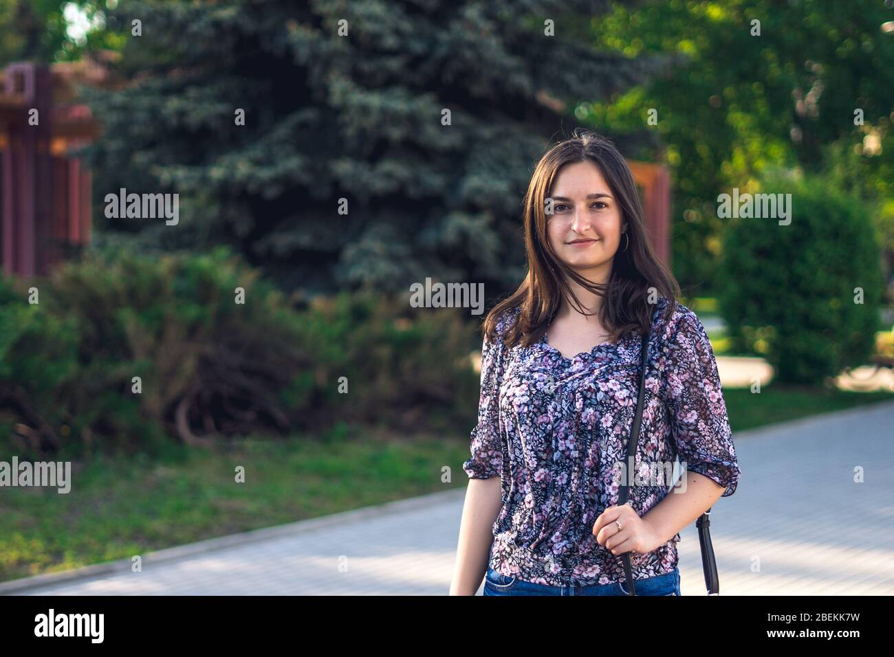 Une fille marche en ville avec un sac à main bleu. Fille brunette dans le parc Banque D'Images