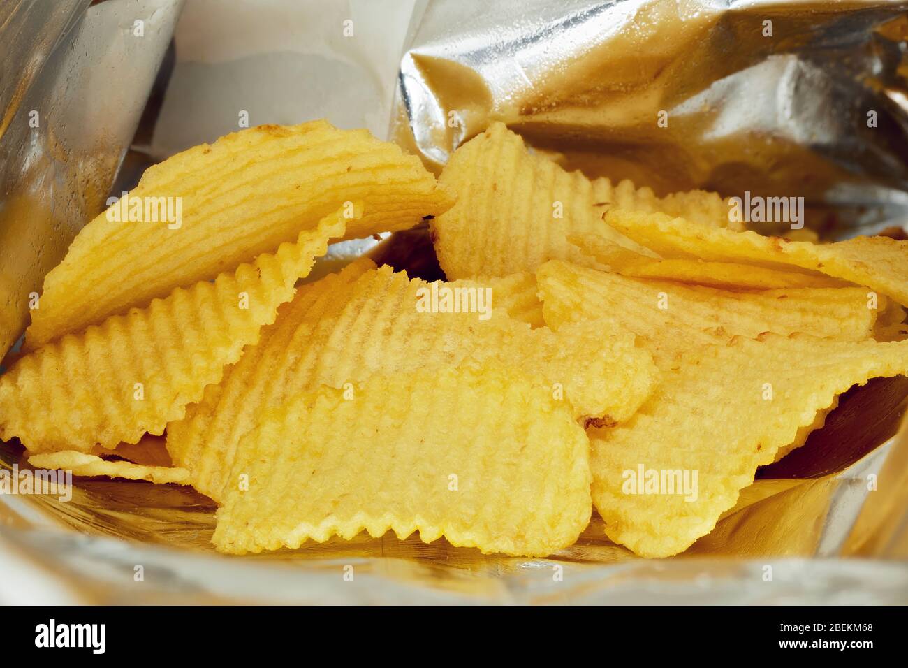 Chips de pommes de terre dans un sac en aluminium ou un paquet argent. Vue rapprochée de la macro. Banque D'Images