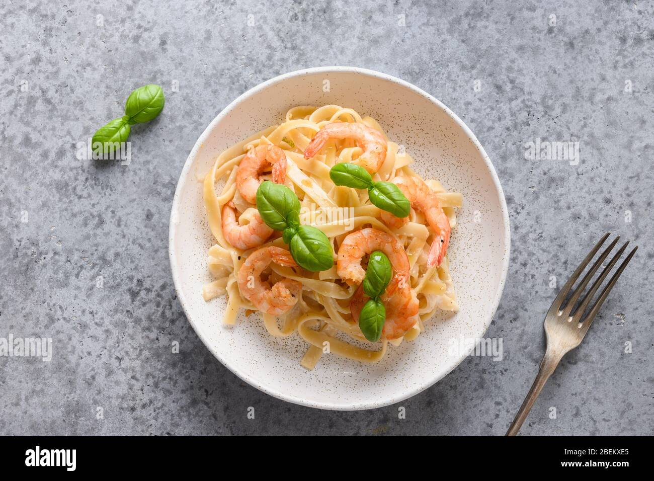 Fettuccine de pâtes italiennes avec crevettes sur table grise. Vue de dessus. Banque D'Images