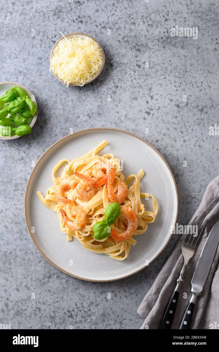 Fettuccine de pâtes italiennes avec fruits de mer, crevettes sur table grise. Prise de vue verticale. Banque D'Images