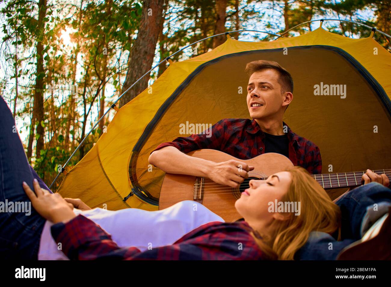 Camping en forêt. Couple amoureux détente agréable nature fond. Petite amie guitare près de la tente de camping. Air frais et sentiments purs. Campin Banque D'Images