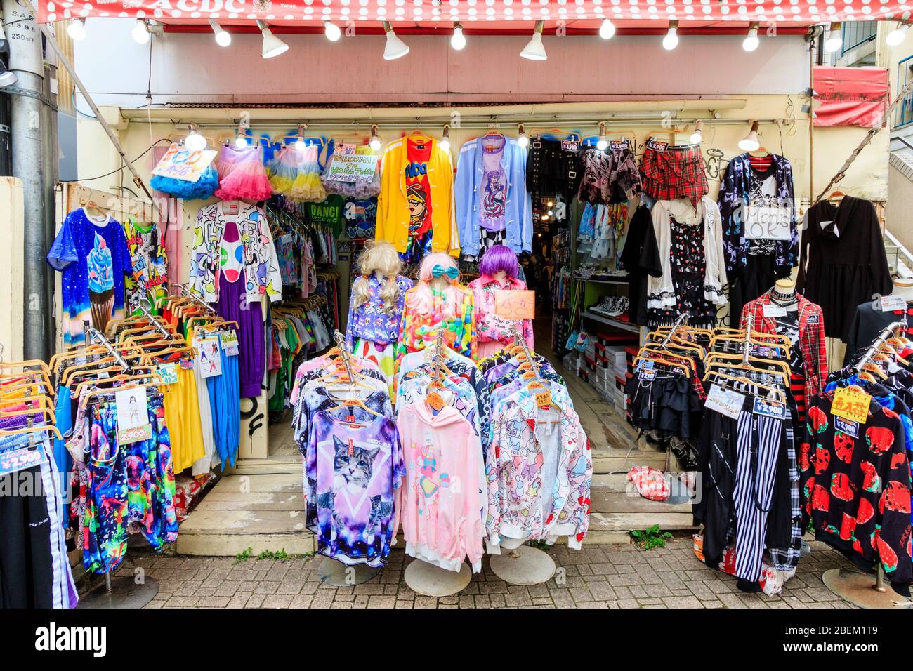 Tokyo, Harajuku, rue Takeshita. Petite branche de la célèbre boutique de mode ACDC Rag. Vêtements sur de nombreux racks sur le pavé à l'extérieur de la boutique et de l'entrée. Banque D'Images