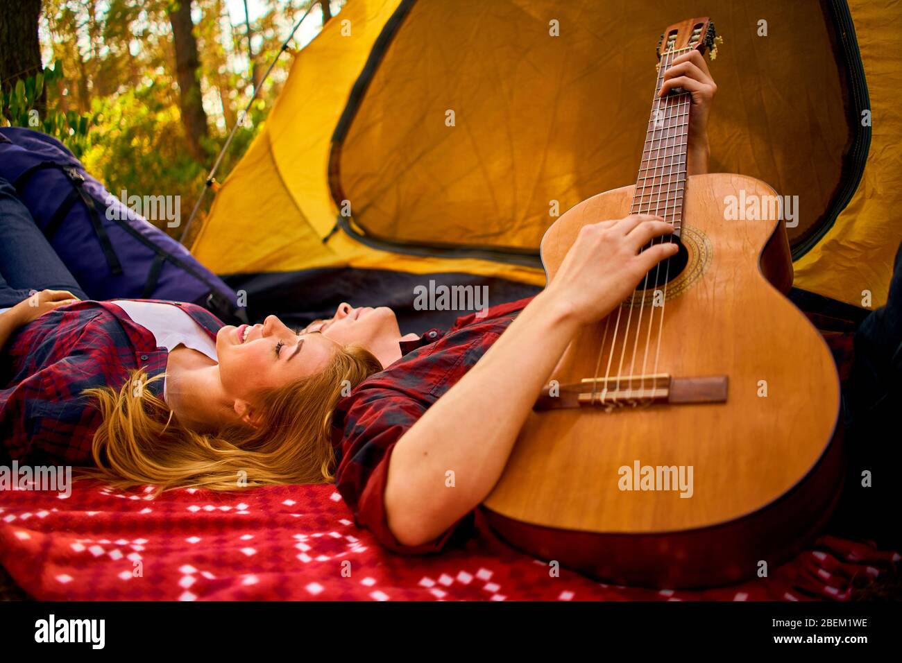 Camping en forêt. Couple amoureux détente agréable nature fond. Petite amie guitare près de la tente de camping. Air frais et sentiments purs. Campin Banque D'Images