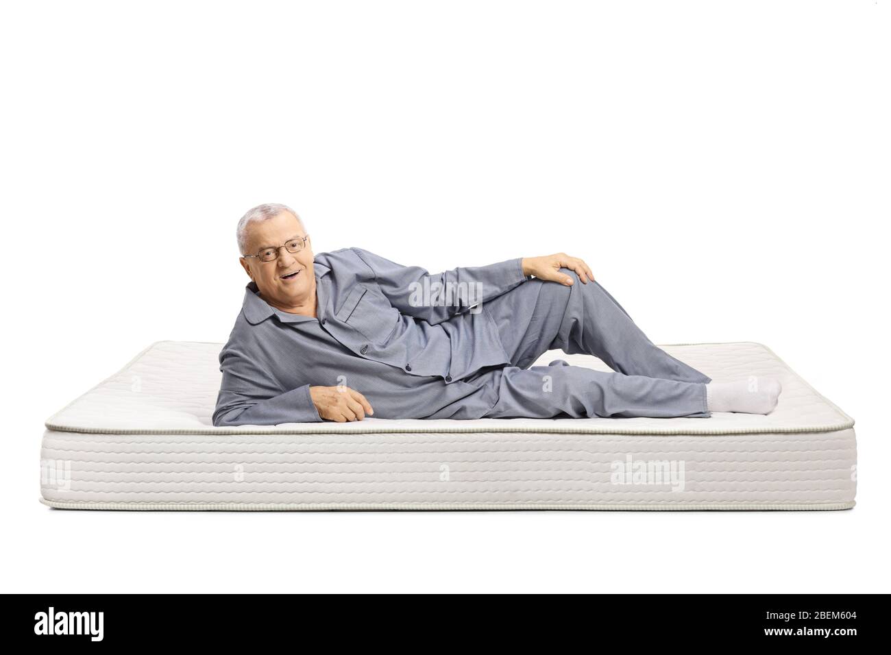 Homme mûr en pyjama allongé sur un matelas de lit et souriant isolé sur  fond blanc Photo Stock - Alamy