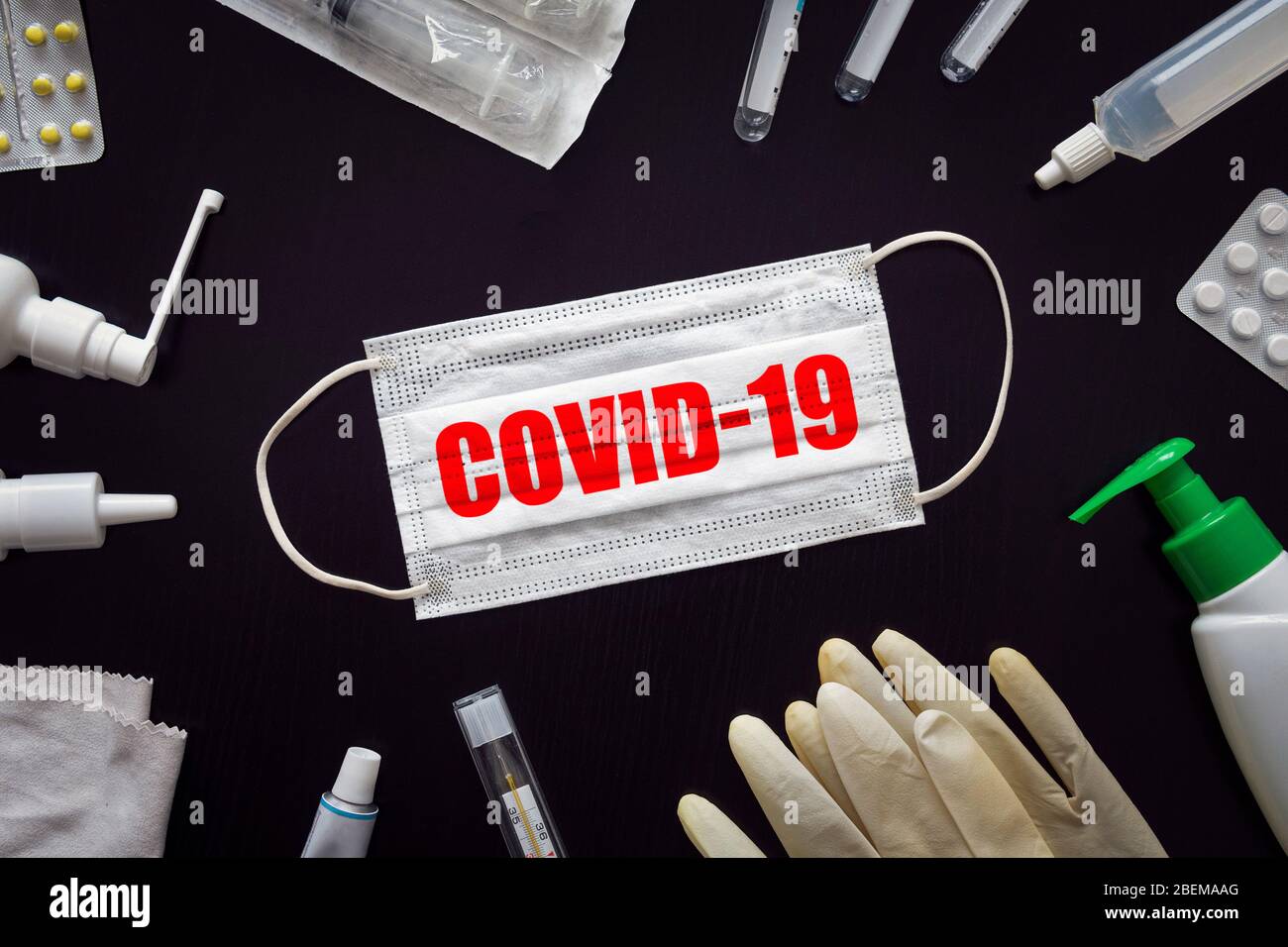 Masque médical et pilules avec inscription COVID-19 sur fond de table noir. Nouveau concept de coronavirus : la lutte contre le virus. S Banque D'Images
