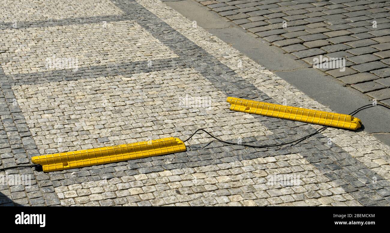 PRAGUE, RÉPUBLIQUE TCHÈQUE - JUILLET 2018: Couvercles en plastique lourd jaune pour véhicule de traverser des câbles posés dans une rue. Un couvercle est hors du câble Banque D'Images