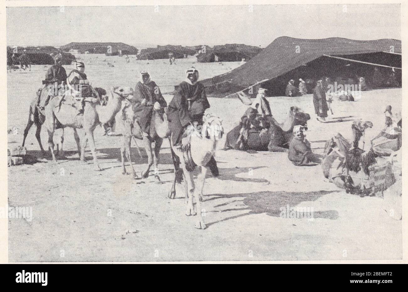 Photo noir et blanc des années 1930 d'un site de camp arabe dans le désert. Banque D'Images