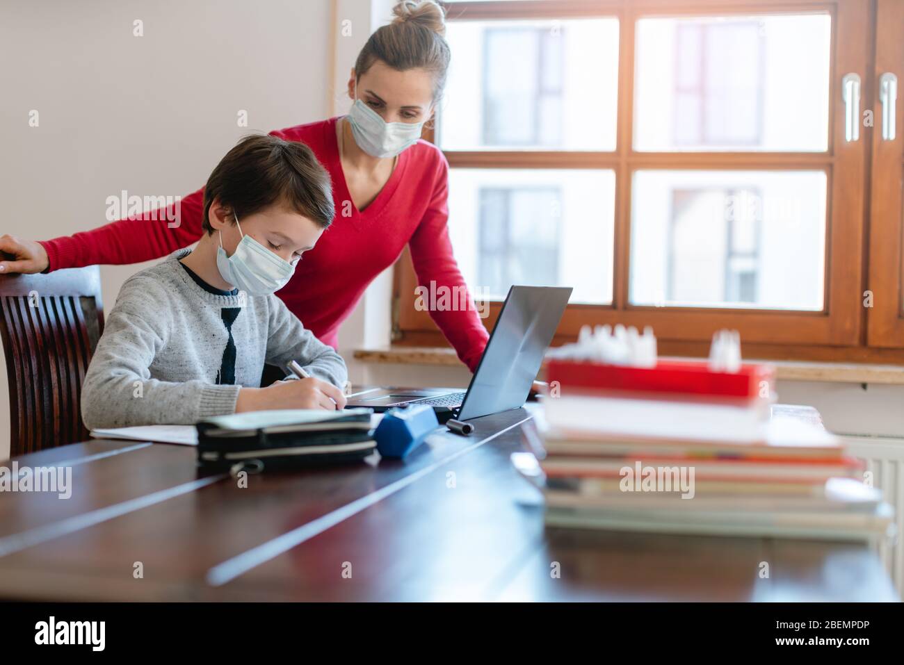 Mère et enfant ayant une séance d'apprentissage en ligne avec l'enseignant pendant la crise Banque D'Images