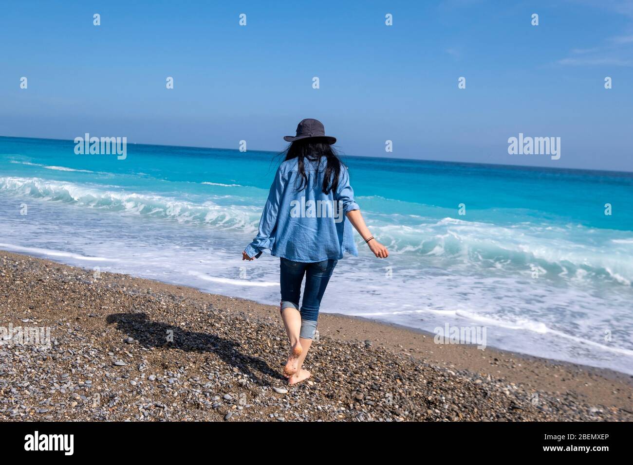 Vue arrière d'une femme qui marche vers la mer Méditerranée à Nice, Côte d'Azur, France, Europe Banque D'Images