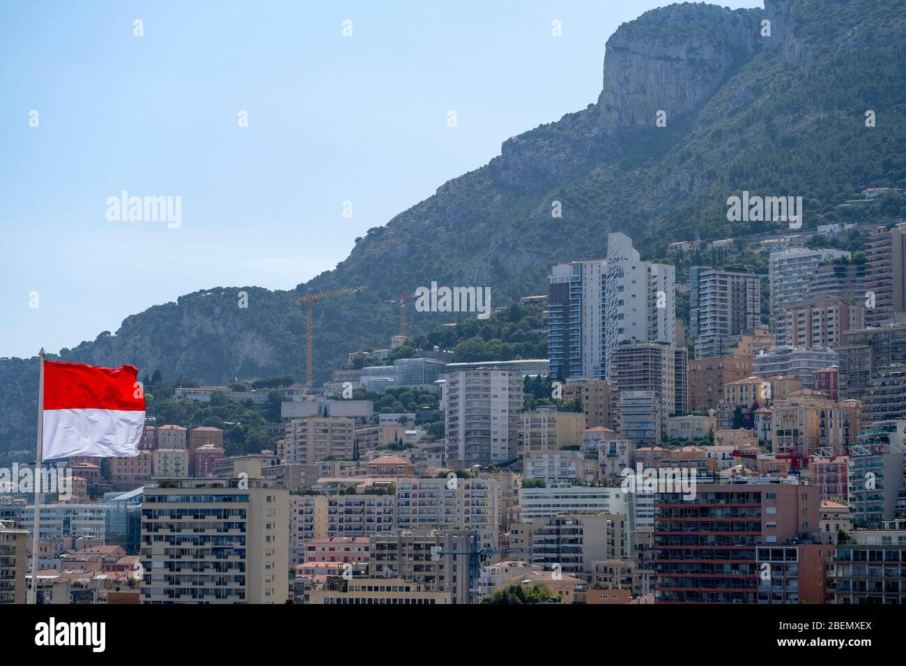 Drapeau monégasque avec bâtiments résidentiels en arrière-plan à Monte Carlos, Monaco, Europe Banque D'Images