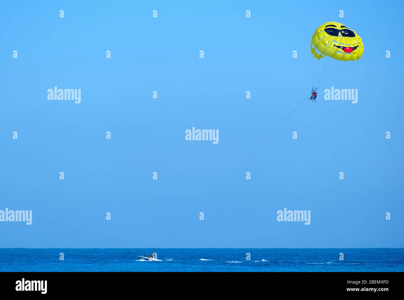 Un couple en parachute ascensionnel est tiré par un hors-bord Banque D'Images