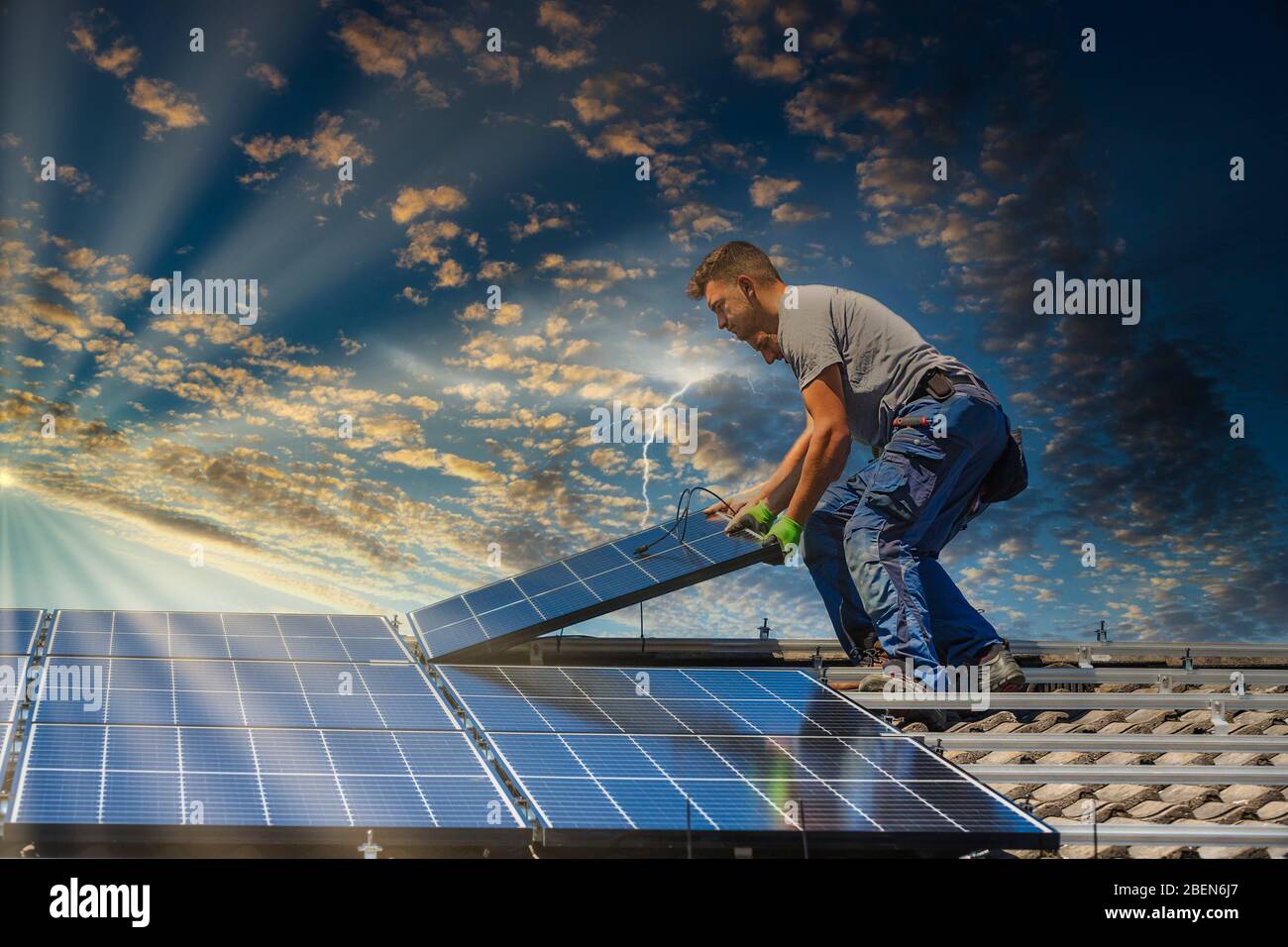 Portrait des travailleurs qui installent des panneaux photovoltaïques sur le toit Banque D'Images