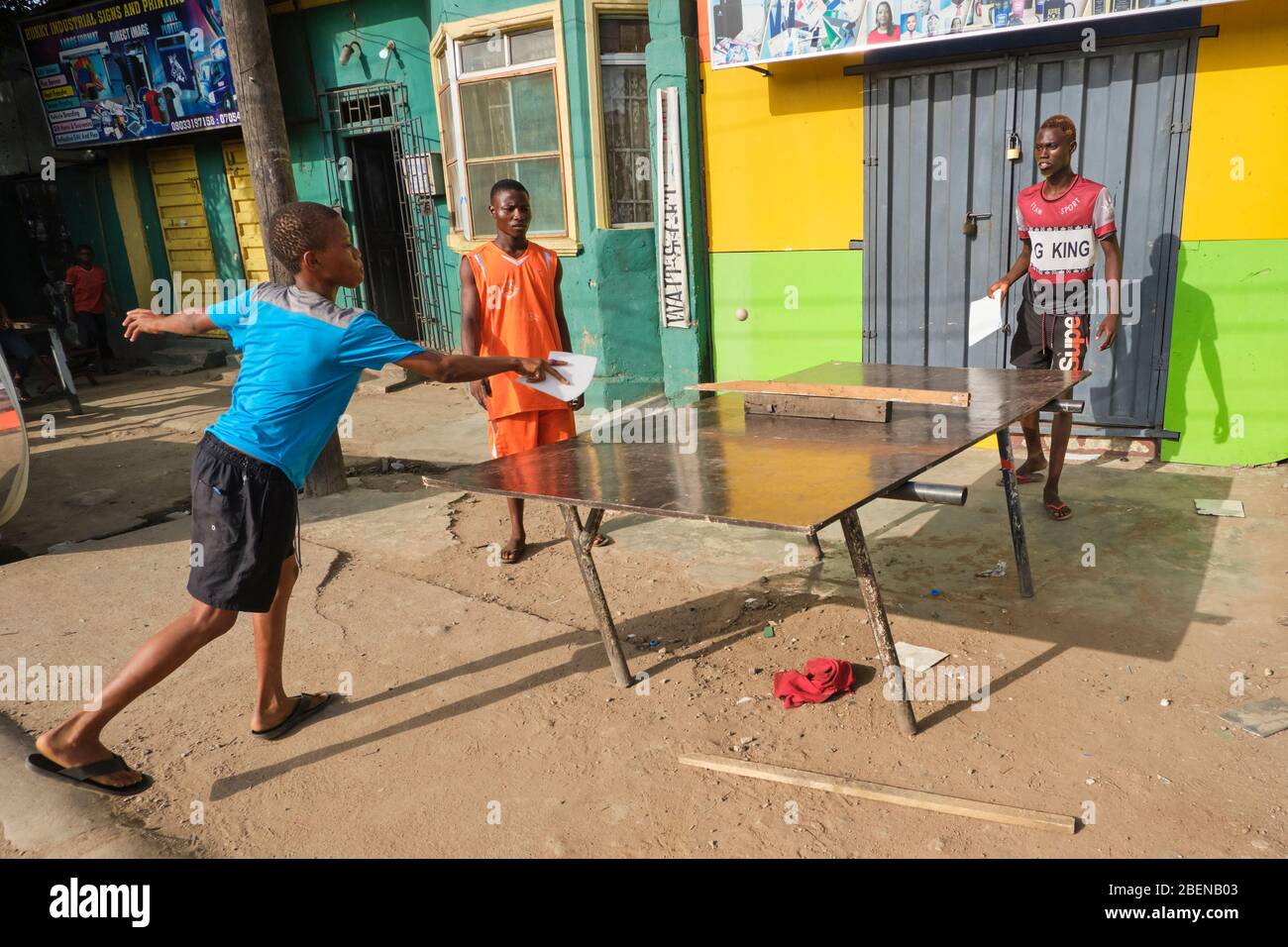 Un groupe de garçons jouent au ping-pong en dehors de leur maison à Lagos, au Nigeria. Banque D'Images