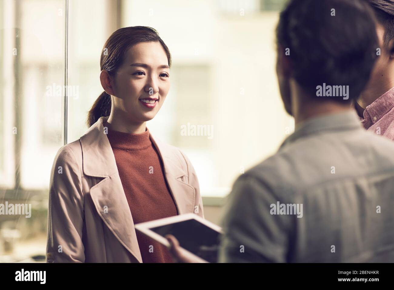 trois jeunes entrepreneurs asiatiques travaillant ensemble au bureau à la recherche d'une tablette numérique Banque D'Images