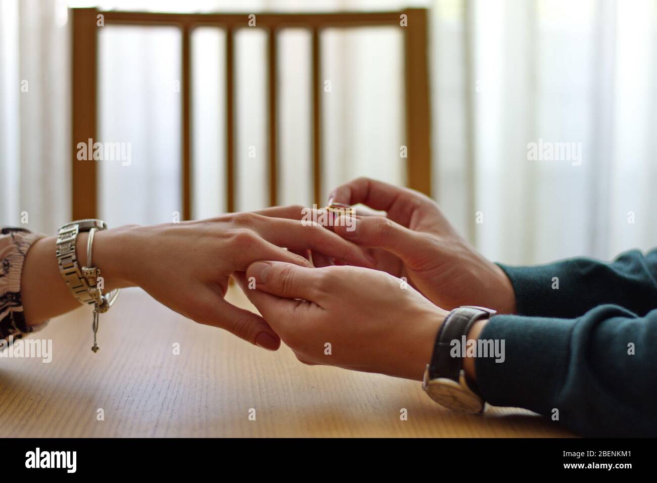 Gros plan de l'homme plaçant l'anneau d'engagement sur le doigt de la femme Banque D'Images