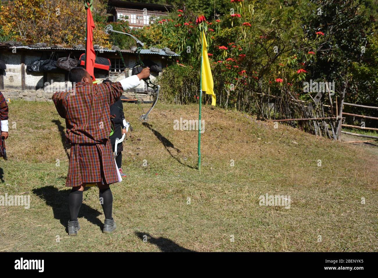 Les hommes vêtisaient d'une robe traditionnelle participent à un concours de tir à l'arc dans un petit village près de Punakha, au Bhoutan Banque D'Images