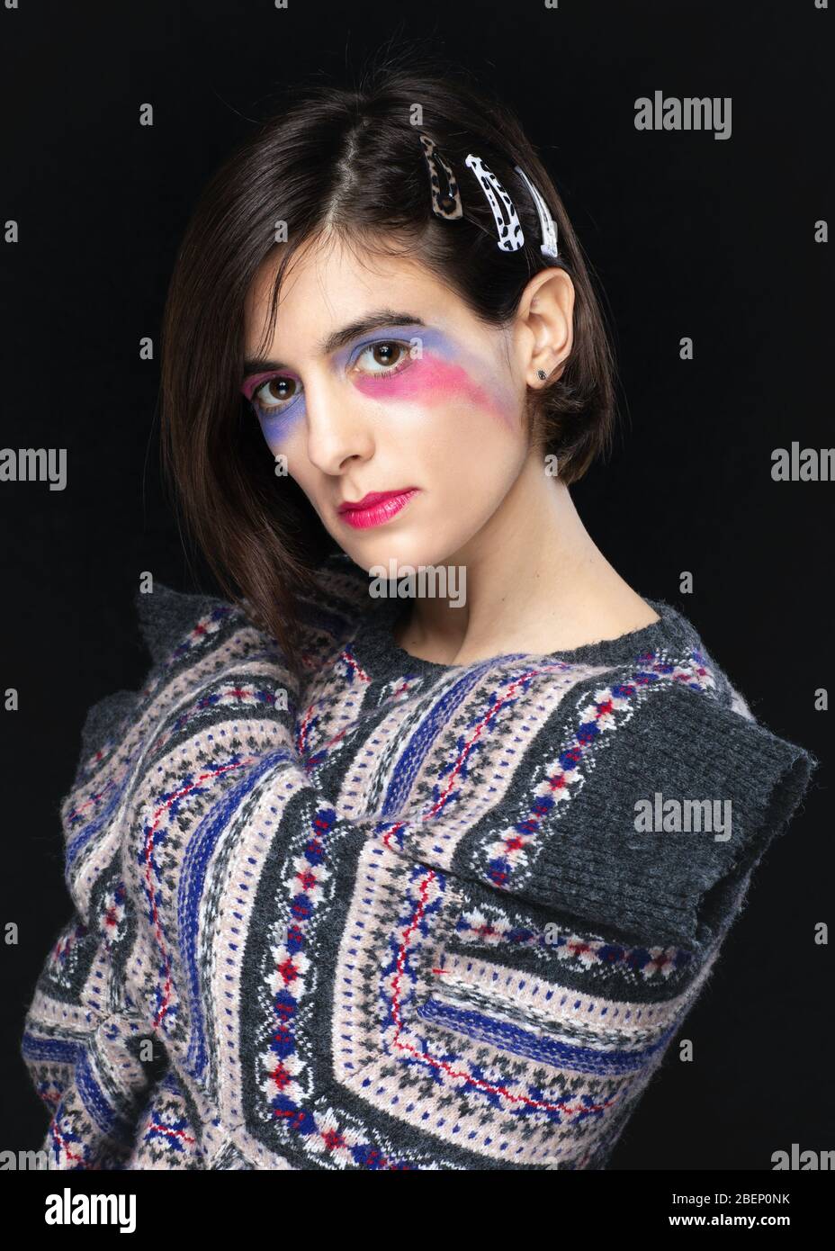 Femme avec composition créative et sweat coloré posant en studio. Modèle de mode en studio. Banque D'Images