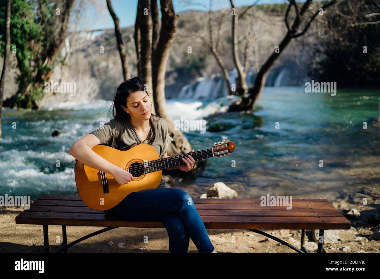 Jeune guitariste jouant de la guitare acoustique et regardant la nature de  la rivière.recherche inspiration.Créateur de musique.nouvel artiste de  bonne humeur.talent musical.Smiling Photo Stock - Alamy