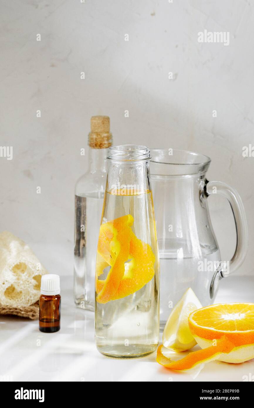 Nettoyant tout usage composé d'ingrédients naturels, vinaigre blanc, eau, zeste citrique et huile aromatique. Détergent organique dans une bouteille de verre Banque D'Images